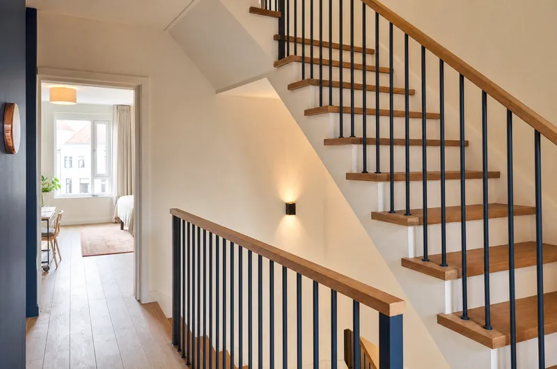 Escalier rénové avec un nouveau garde-corps à barreaux verticaux et main courante en chêne